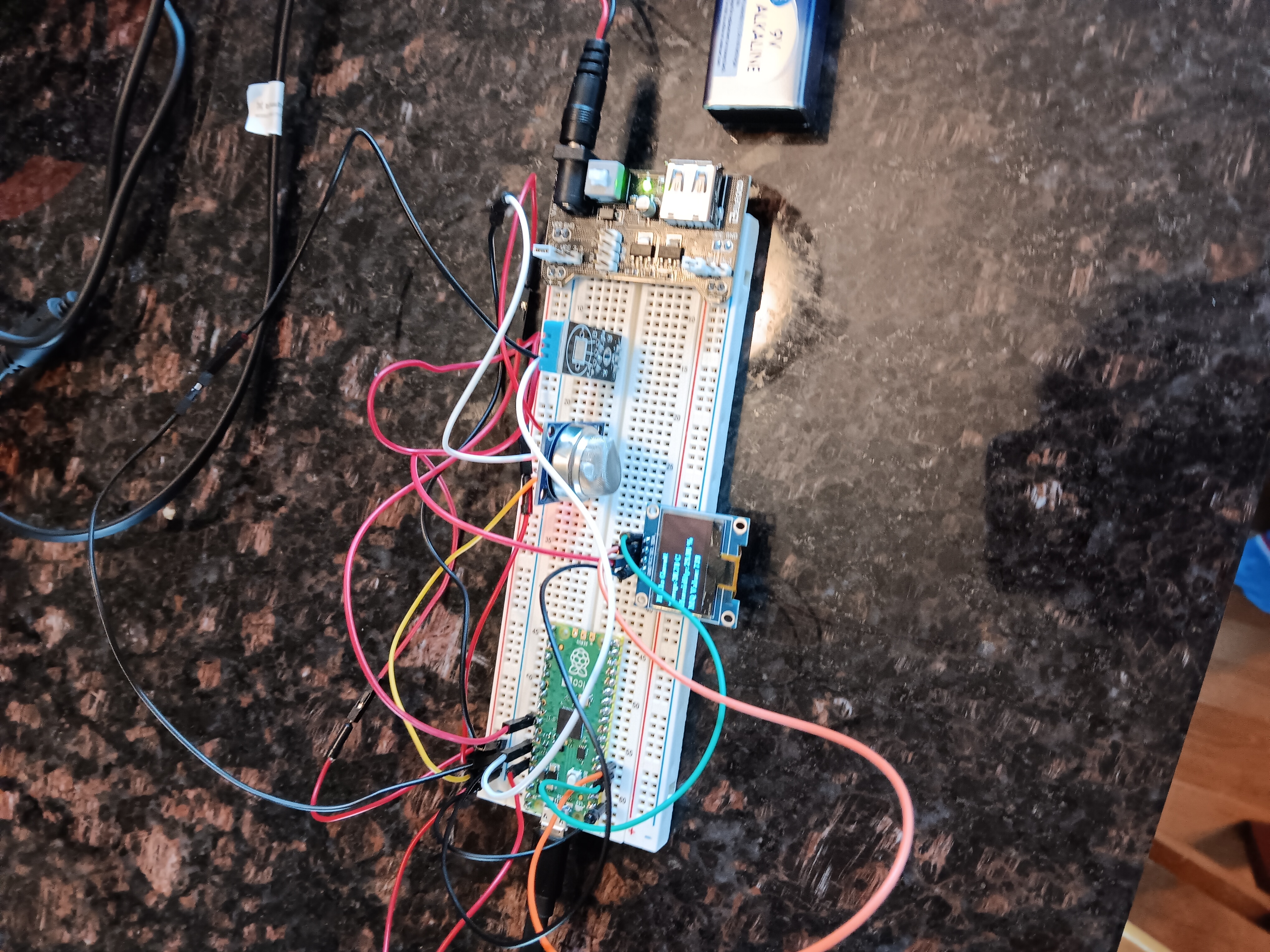 A photo showing the Raspberry Pi Pico wired to a breadboard with an OLED display and sensors.